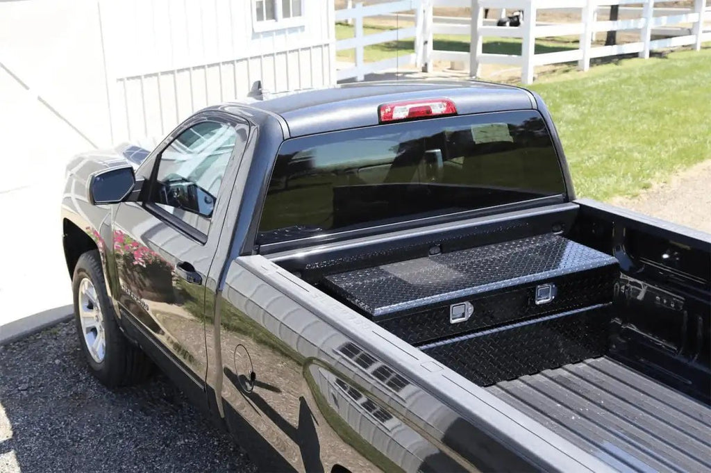 Black 48-inch aluminum crossover tool box installed across the bed of a pickup truck
