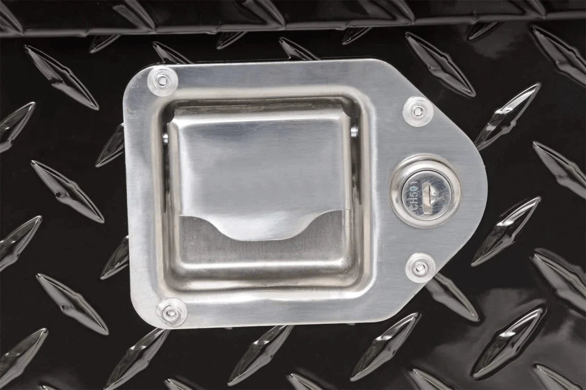 Close-up of recessed stainless steel paddle latch on the black aluminum truck tool box