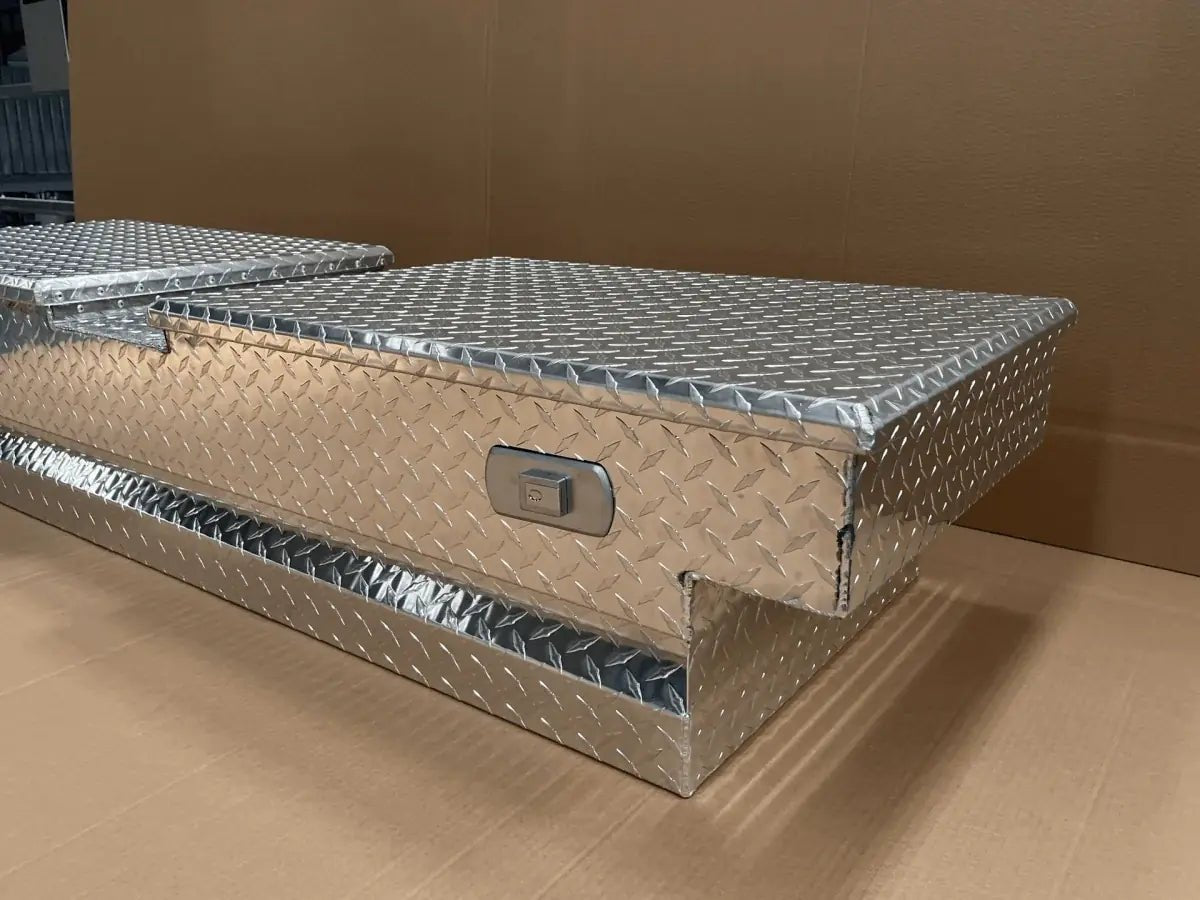 Lockable aluminum truck bed storage box with raised diamond plate lid and crossover base