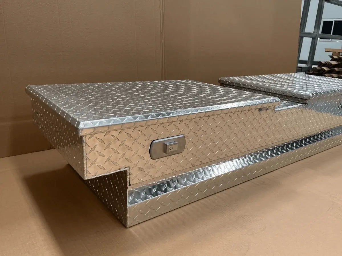 Three-quarter view of diamond plate pickup bed tool box with recessed locking side compartment