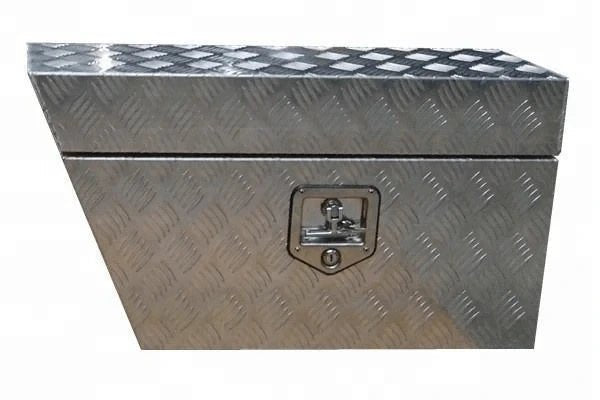 Three-quarter view of tapered aluminum ute storage box with lockable checker plate door