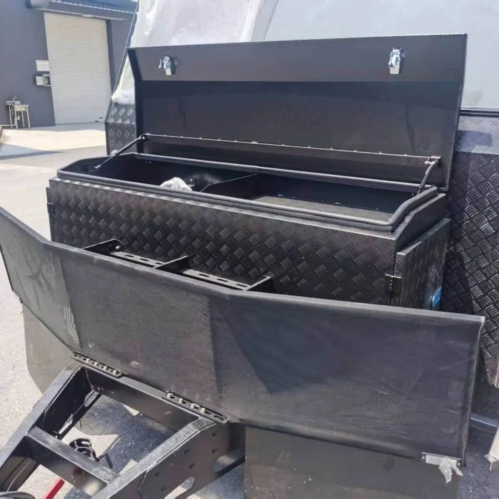 Open black aluminum truck storage box mounted on a trailer with full-width front access panel
