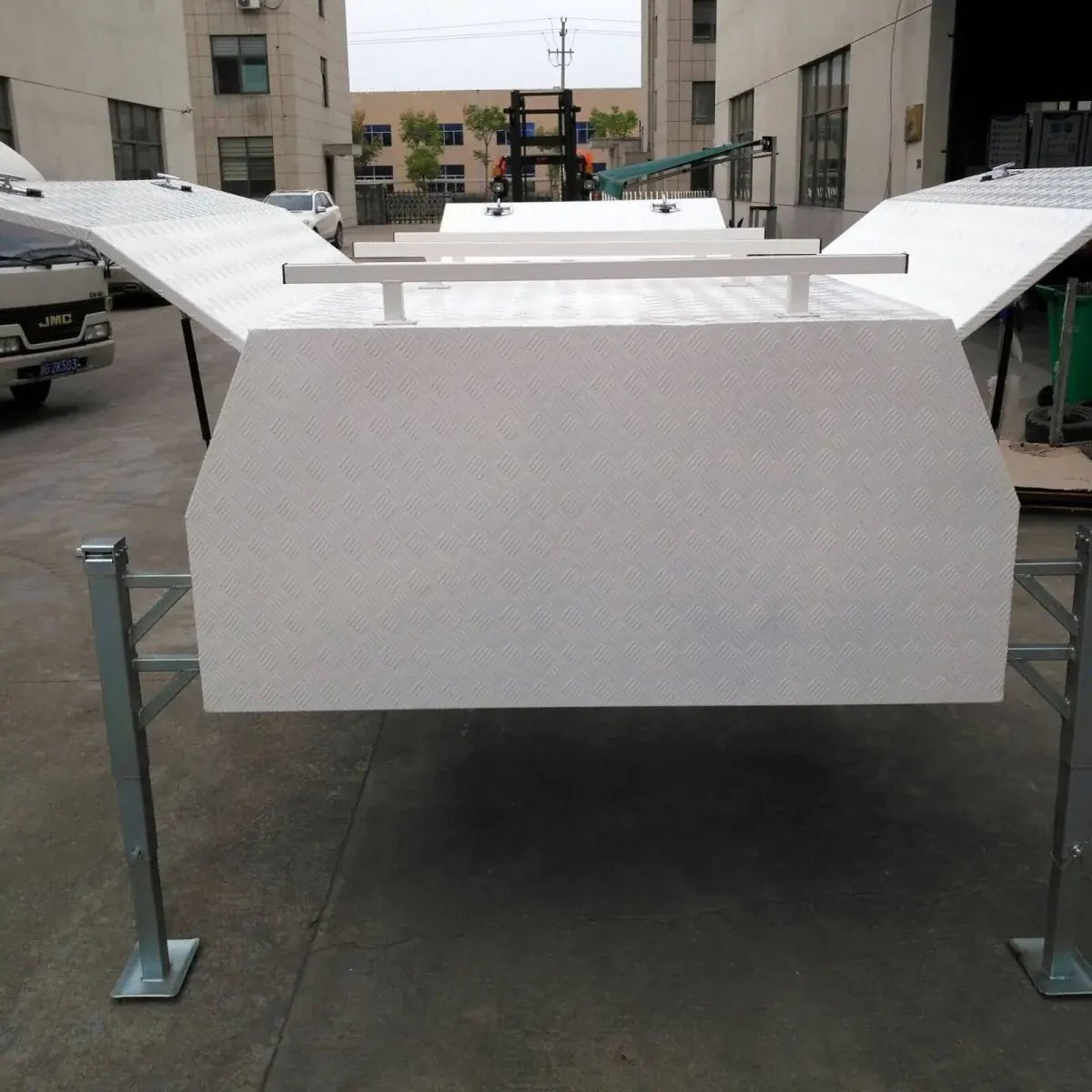 Wide rear view of checker plate canopy storage box with both upper side doors raised